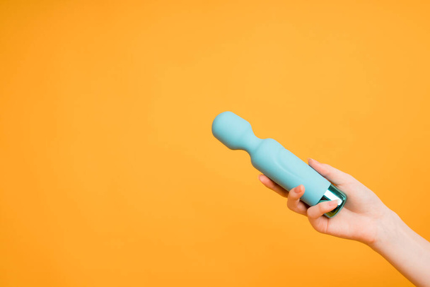 Blue vibrator or masturbation massager on an orange background. Flat Lay. Sex shop concept - Фото, изображение