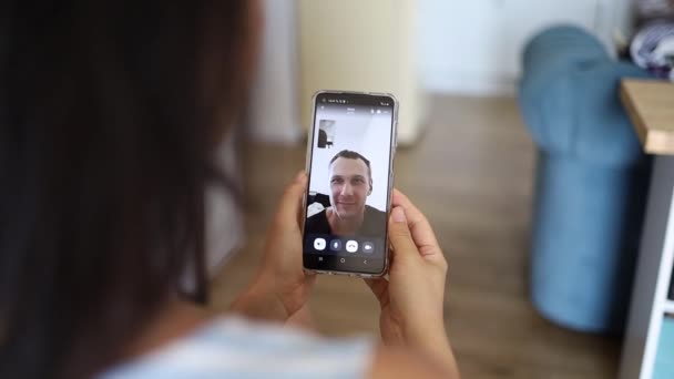 Mujer teniendo chat de vídeo con un amigo utilizando el teléfono inteligente disfrutando de la comunicación con la familia en la conexión del teléfono móvil - Metraje, vídeo