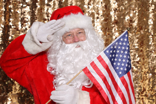 Santa Claus. Santa Claus holds an American Flag. Santa is all American. Gold Sequin background. Christmas Images. - Photo, image