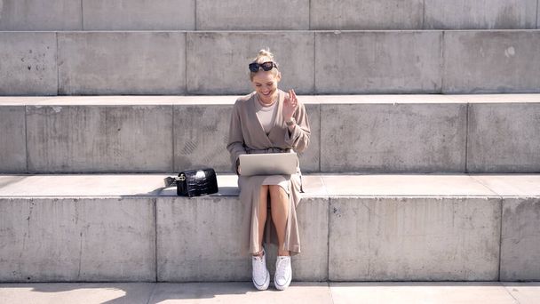 Trendige Frau macht Videoanruf auf Stufen - Foto, Bild