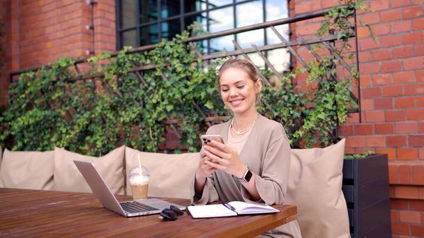Freelancer feliz usando smartphone en cafetería - Foto, Imagen