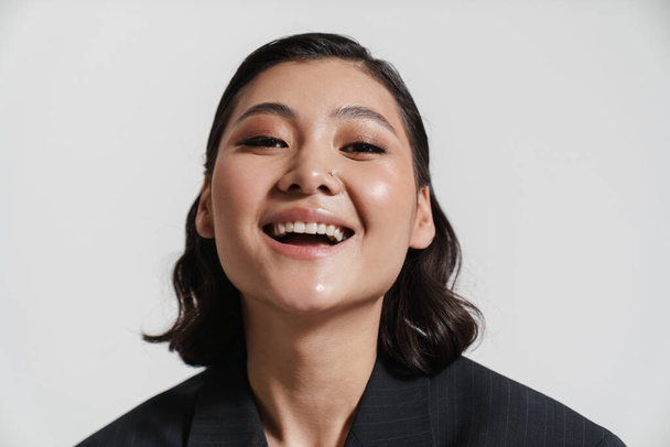 Bruna asiatico donna indossare giacca ridere a macchina fotografica isolato su sfondo bianco - Foto, immagini