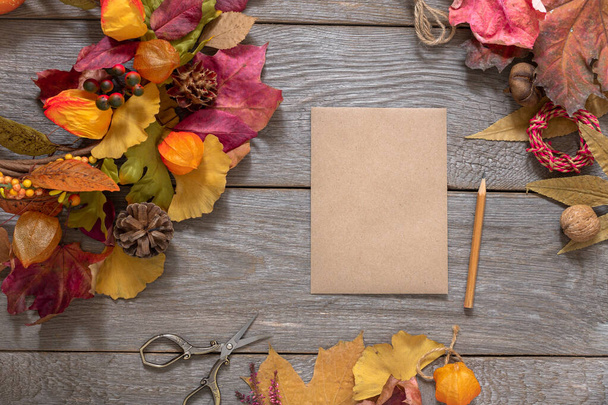 autumn design, layout with colorful fallen leaves and blank sheet of craft paper on wooden table, autumn note, background for design - Zdjęcie, obraz