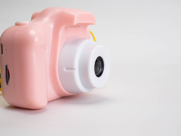 Photo d'un appareil photo rose jouets sur un fond blanc - Photo, image