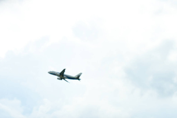 Ladkrabang Tajlandia 24 sierpnia 2019 Smuga Samolot pasażerski leci na niebieskim niebie nad chmurami i drzewem. Samolot pasażerski ląduje na lotnisku Suvarnabhumi. - Zdjęcie, obraz