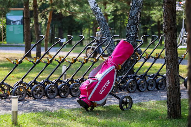 Minsk. Belarus - 24.07.2021 - Push-Pull Golf Carts. Green grass, trees. - Foto, Imagen