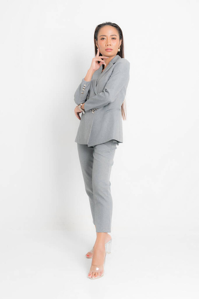 Fashion style catalog clothing for business woman black long hair natural make up wear gray suit costume perfect body shape suit at studio shoot on white background and shadow. - 写真・画像