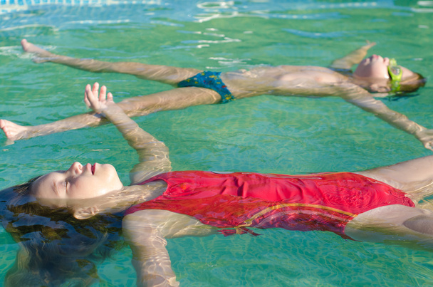 Menino e menina litlle flutuando na superfície da água do
 - Foto, Imagem
