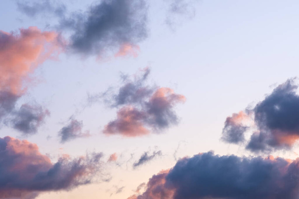 Багато маленьких хмар на помаранчевому синьому фоні неба. Драматичне небо під час заходу сонця
. - Фото, зображення