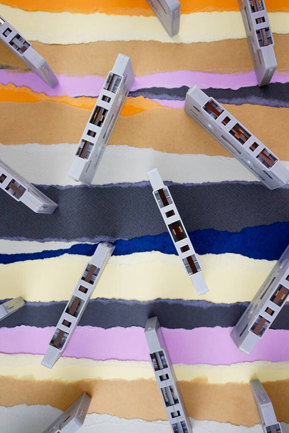 カセットテープ,古典的なヴィンテージアンティーク郷愁フラットレイ上の引き裂かれた色の紙の背景. - 写真・画像