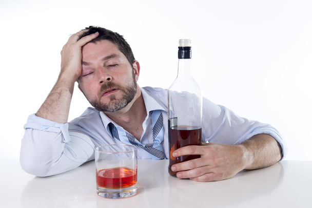 Businessman wearing blue shirt drunk at desk on white background - Фото, зображення