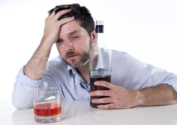 Businessman wearing blue shirt drunk at desk on white background - Photo, Image