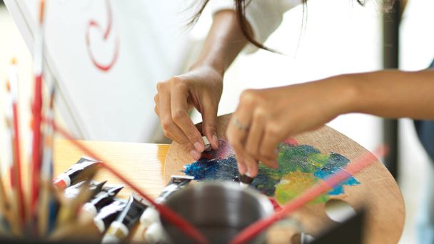 Closeup, female hands mixed acrylic colour on art palette, art worker, artist, painting, painting tools - Fotografie, Obrázek