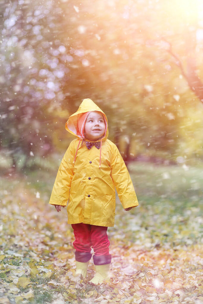 秋の日に外を散歩用レインコートの子供 - 写真・画像