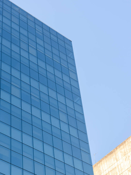 A low angle view of the windows on the walls of the skyscraper on a sunny day - Photo, image