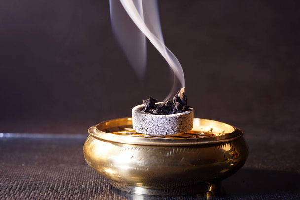 A burning incense on a metal bowl - Foto, Bild