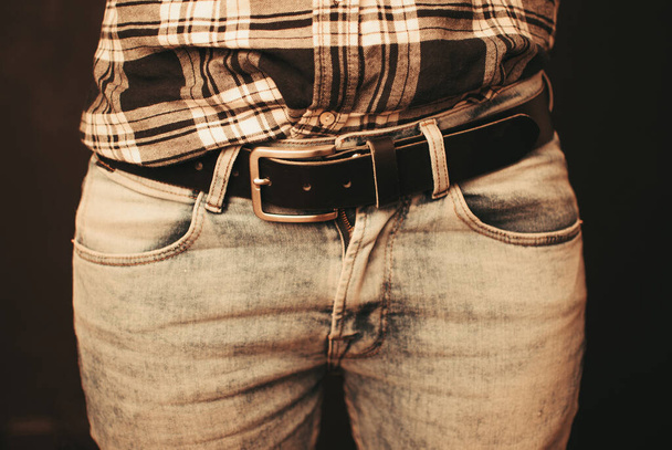 The details of fashion clothes, the gray jeans with a leather belt - Fotoğraf, Görsel