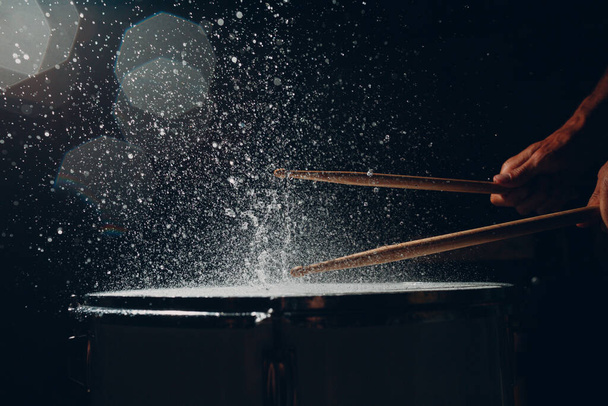Bubnové tyčinky bubnování rytmus na buben povrchu s kapkami stříkající vody - Fotografie, Obrázek