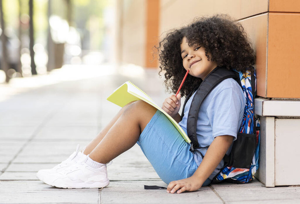 kleine jongen op school met notebook pensive, kleuterschool, schooluitje - Foto, afbeelding