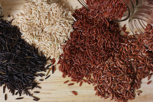 Riso selvatico nero sul tavolo di legno con riso integrale e rosso himalayano - Foto, immagini