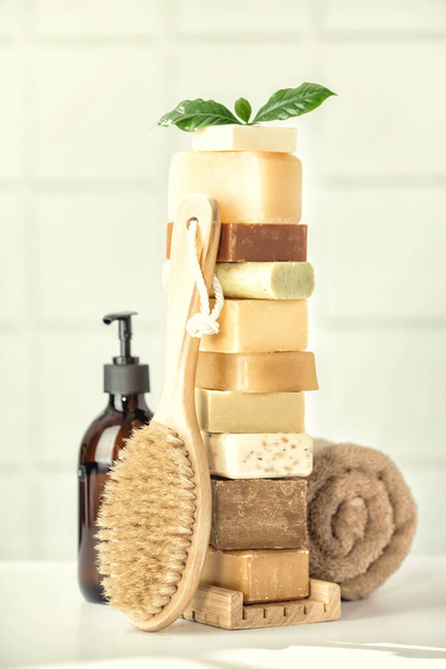 Stack of assorted natural soap bars on white bathroom countertop - Foto, Imagen