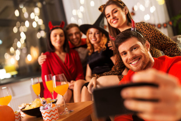 happy friends in halloween costumes taking selfie - Фото, зображення