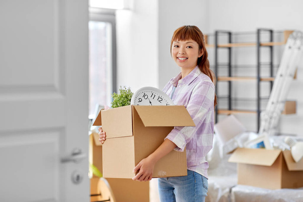 happy woman unpacking boxes and moving to new home - 写真・画像