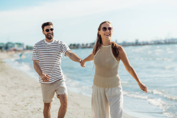 happy couple walking along summer beach - Fotoğraf, Görsel