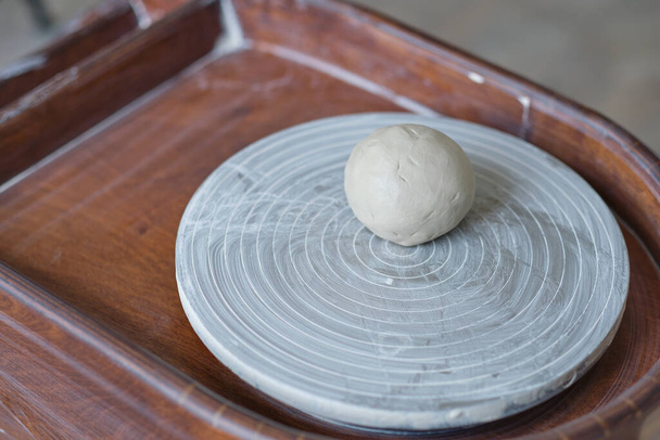 Atelierdetail einer Töpferscheibe mit gekochtem Ton. Workshop zur Herstellung von Tonschalen. - Foto, Bild