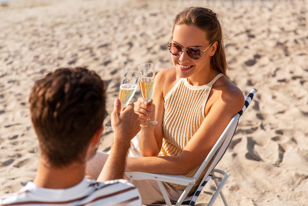 happy couple drinking champagne on summer beach - Фото, зображення