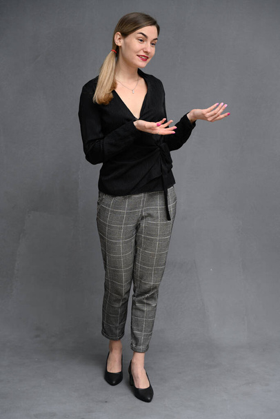 vertical full length photo business portrait young woman posing talking in studio on gray background - Foto, afbeelding