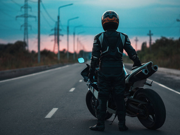Motociclista en moto. El camino a la puesta del sol. - Foto, Imagen