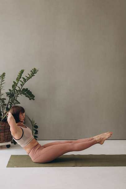 Mujer mayor activa practicando yoga en interiores. Ejercicio para adultos mayores - Foto, imagen