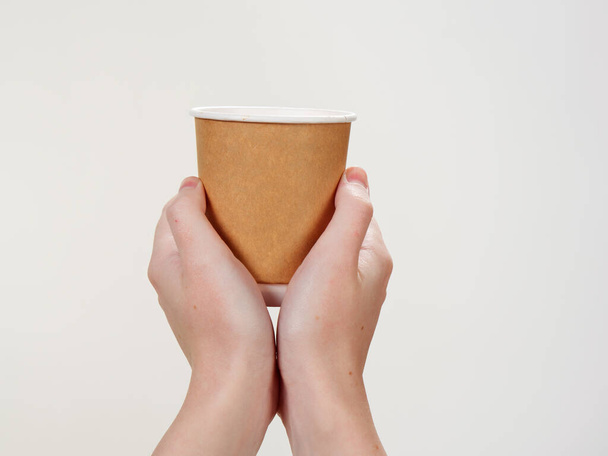 Tek kullanımlık kahve kağıdı elinizdeki çevre dostu fincan beyaz arka planda 2021 - Fotoğraf, Görsel