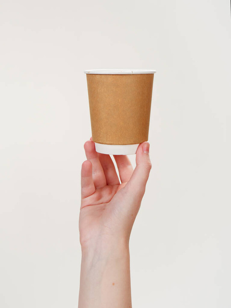 disposable coffee paper eco friendly cup in hand isolated on white background 2021 - Foto, Imagem