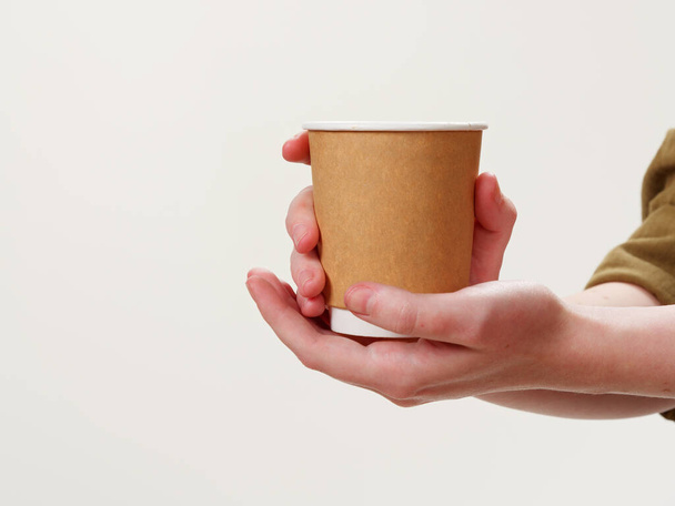 disposable coffee paper eco friendly cup in hand isolated on white background 2021 - Φωτογραφία, εικόνα