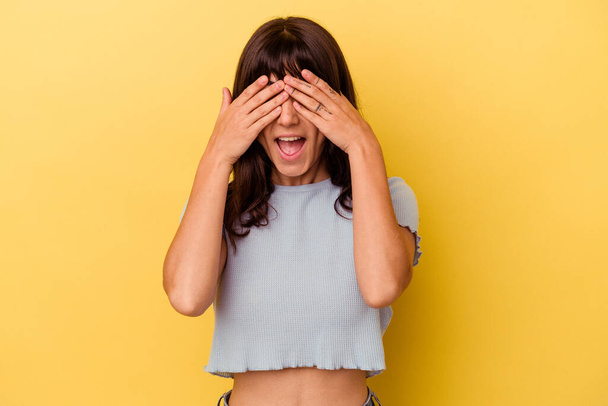 Young caucasian woman isolated on yellow background covers eyes with hands, smiles broadly waiting for a surprise. - Foto, imagen
