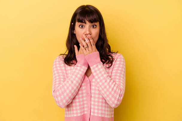 Young caucasian woman isolated on yellow background shocked, covering mouth with hands, anxious to discover something new. - Foto, Imagen