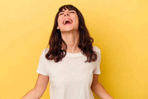 Jonge blanke vrouw geïsoleerd op gele achtergrond ontspannen en gelukkig lachen, nek gestrekt tonen tanden. - Foto, afbeelding