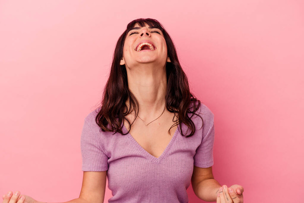 Young caucasian woman isolated on pink background relaxed and happy laughing, neck stretched showing teeth. - Fotografie, Obrázek