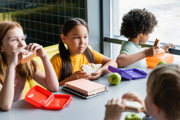 multiethnic children having lunch in school eatery - Fotó, kép