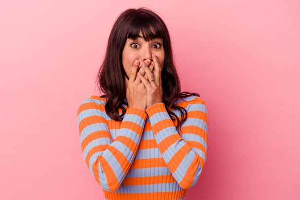 Young caucasian woman isolated on pink background shocked, covering mouth with hands, anxious to discover something new. - Photo, Image