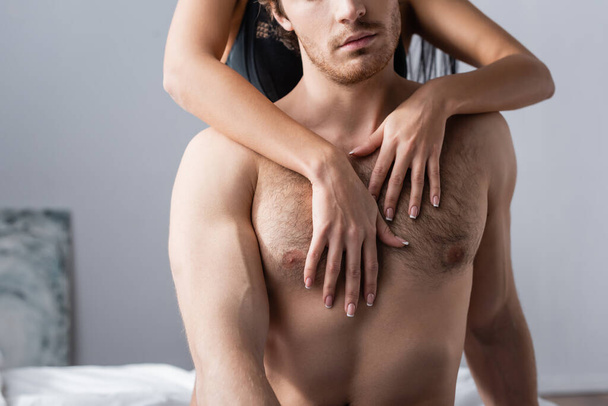 partial view of young girlfriend hugging shirtless boyfriend - Fotó, kép