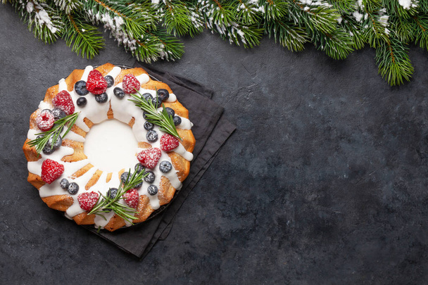 Christmas cake with berries and fir tree. Top view flat lay with space for your greetings - Photo, Image