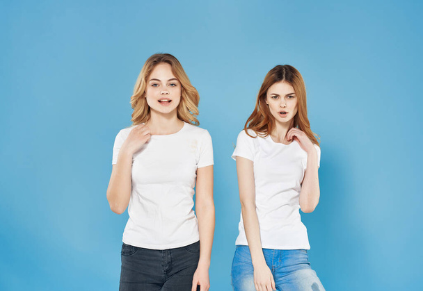 two sisters in white t-shirts emotions modern style blue background - Fotografie, Obrázek