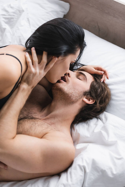 high angle view of passionate couple kissing in bedroom  - Photo, Image