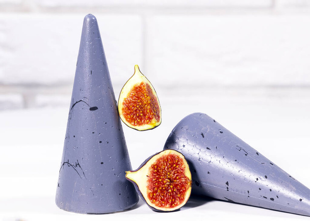 Fresh Fig with mint leaf on gray stands and podiums over white background, Healthy Summer Food, Creative Concept, Top view, equilibrium food - Fotó, kép