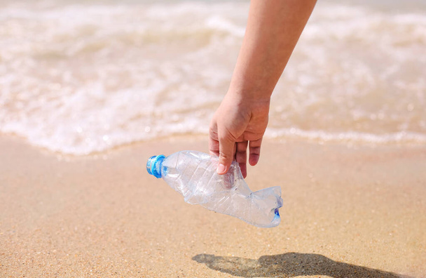 Добровольцы собирают мусор, пластиковые мусорные бутылки и маску на пляже. Концепция экологии, окружающей среды, загрязнения и экологических проблем - Фото, изображение