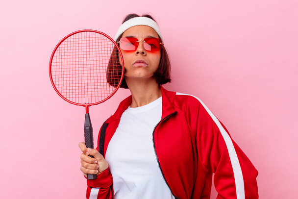 Young mixed race woman playing badminton isolated on pink background - Photo, Image