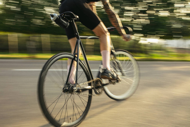 Velocidad en bicicleta por carretera en el día de verano. Deporte, concepto de estilo de vida activo - Foto, imagen